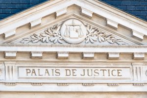 Fronton d'un palais de justice français, symbole de la balance et devise Lex