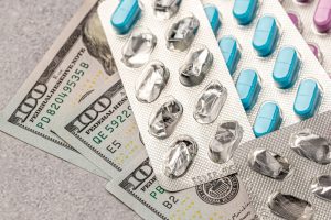 Plaquettes de médicaments posées sur des billets de dollars
