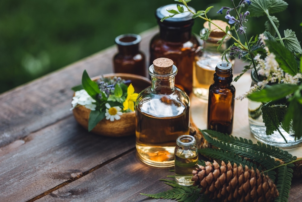 Flacons d'huiles essentielles et plantes médicinales sur une table en bois