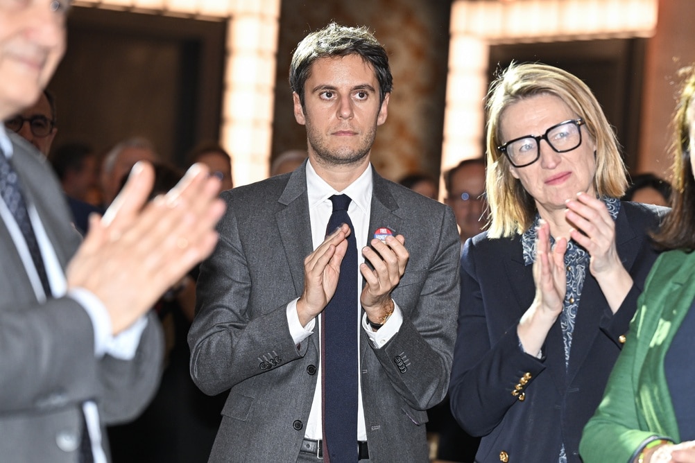 Gabriel Attal applaudit lors d'un événement politique