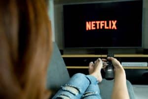 Personne regardant Netflix sur sa télévision, télécommande en main